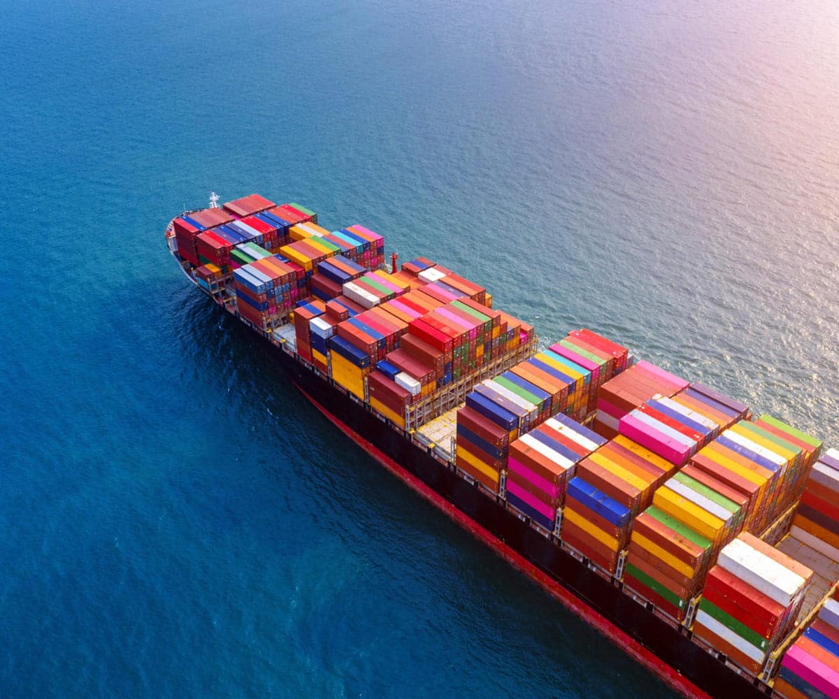 Cargo ship sailing with stacked containers for sea freight services